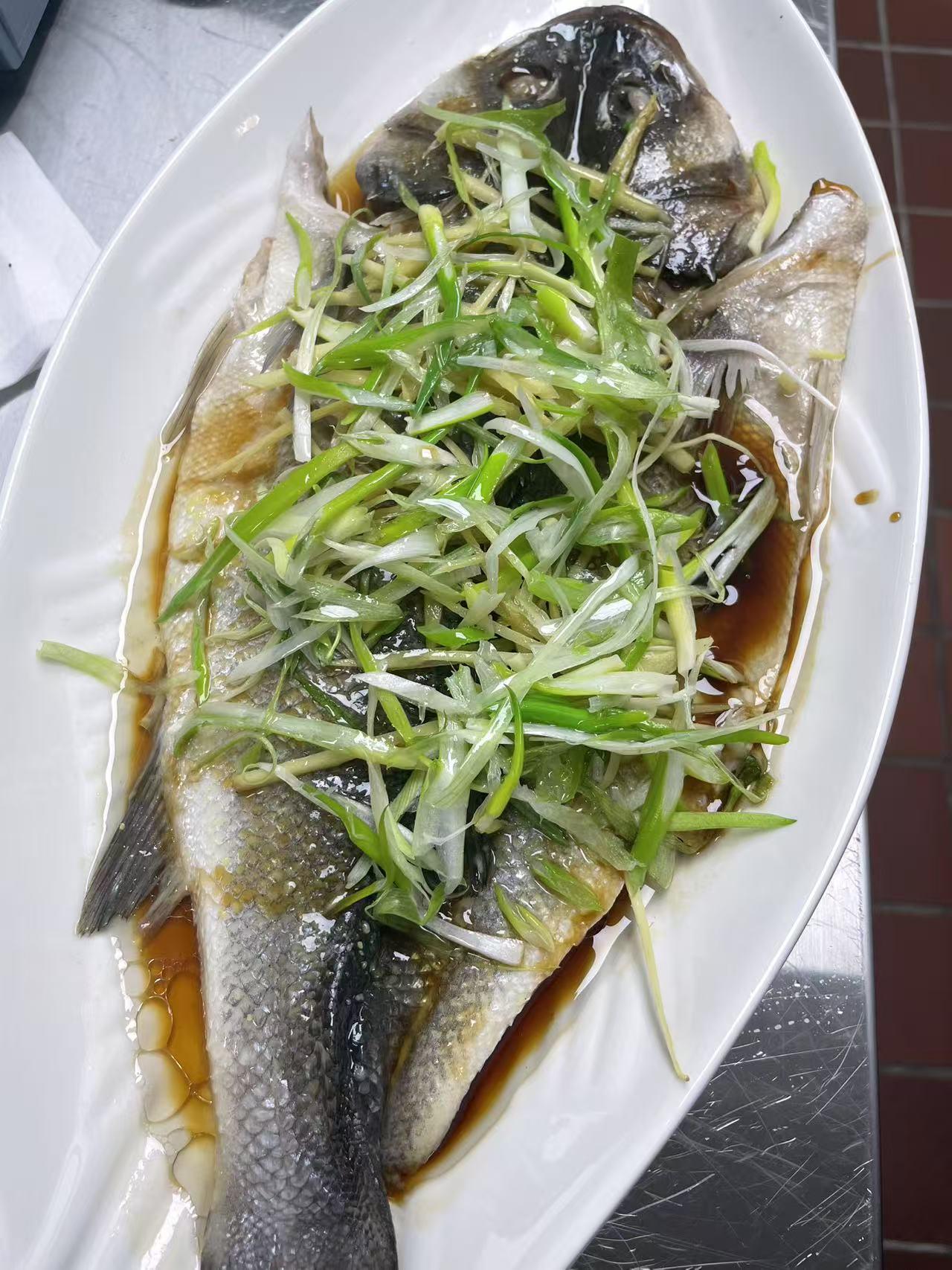 A whole steamed fish topped with scallions, from Ye’s Seafood House’s gallery